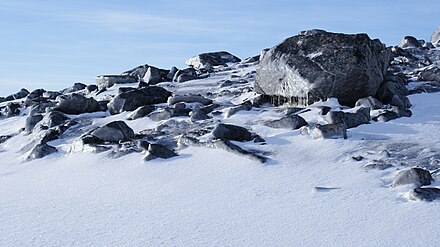 Moraine boulders under Qalorujoorneq: rime ice windblasted on the northeast-facing surfaces