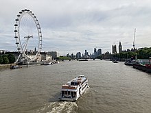 London Eye as a boat passes on the River Thames, with Big Ben in the background London Eye and a boat going down the Thames.jpg