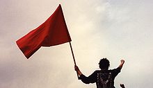 Left-wing protester wielding a red flag with a raised fist, both symbols of revolutionary socialism Madrid may day375.jpg