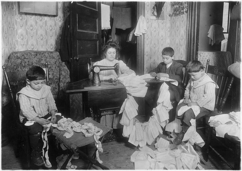 File:Making dresses for Campbell kids dolls in a dirty tenement. The older boy, about 12 years old, operates the machine... - NARA - 523529.tif