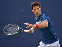 Tennis player Novak Djokovic preparing to hit a shot.
