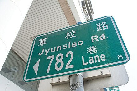 Road sign in Nanzih District, Kaohsiung, showing Tongyong pinyin without tone marks. The sign in Hanyu pinyin would be Junxiao Road.
