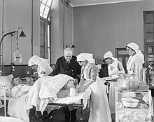 RNH Chatham during the First World War: a naval surgeon, two QARNNS nurses and members of the VAD attend to a wounded sailor. The Medical Services on the Home Front, 1914-1918 Q18929.jpg
