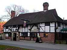 The Old Punch Bowl, Crawley, West Sussex. Parts of the lower wall on the right have been completely replaced with bricks and the jettied upper floor is only visible on the left end. The Punch Bowl, High Street, Crawley (IoE Code 363350).JPG