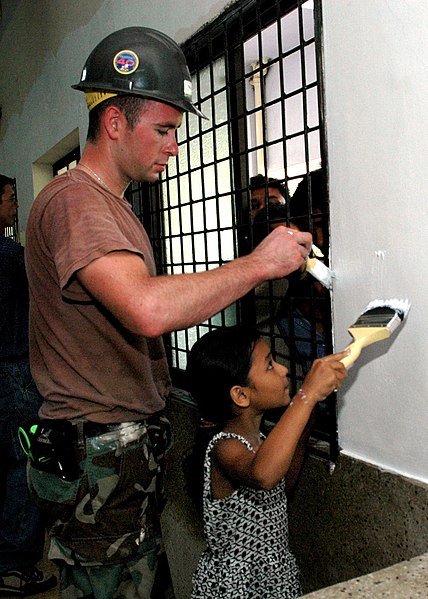 File:US Navy 060702-N-3714J-101 Navy Builder 2nd Class Shane Murray from Poughkeepsie, N.Y., assigned to Naval Mobile Construction Battalion Four Zero (NMCB-40), receives help from a local girl while painting the pediatric ward at t.jpg