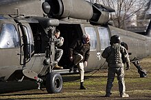Sanders steps out of a Sikorsky UH-60 Black Hawk helicopter after arriving in Afghanistan in 2011 110220-N-9584H-089.jpg