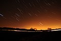 Kurze Lichtstreifen an einem dunklen Himmel, die Sternenspuren zeigen, die mit einer langen Belichtungszeit fotografiert wurden.