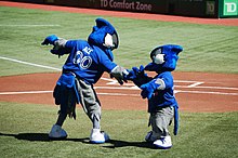 Ace and Junior exchange greetings before the game. Ace was the Blue Jays' second mascot, introduced in 2000. Junior is a mascot occasionally seen for Junior Jays day promotions. Ace and Junior exchange greetings before the game (7968713240).jpg