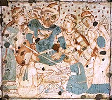 A foreigner in Sasanian dress drinking wine, on the ceiling of the central hall of Cave 1, likely a generic scene from an object imported from Central Asia (460-480 CE) Ajanta foreigner 1.jpg
