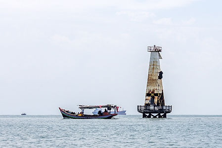 Boat passing ruined lighthouse, Teluk Penyu Beach