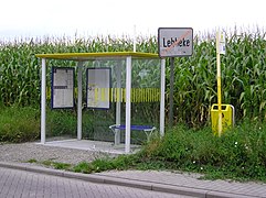 Tato zastávka v Belgii má baldachýn se střechou, lavičky, trasy a jízdní řády autobusových linek a odpadkový koš.