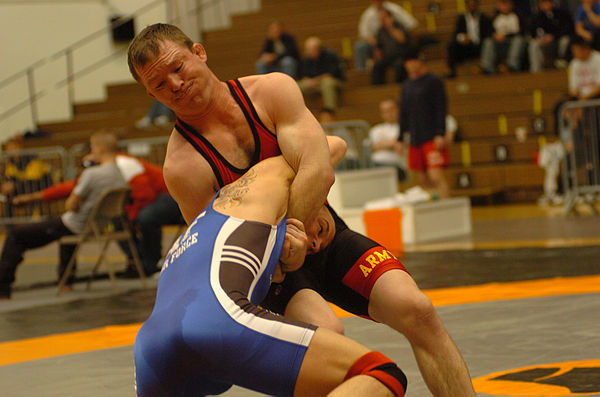 A freestyle wrestler locks the arms of his opponent in order to take him down to the mat