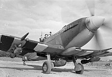A Supermarine Spitfire Mk. IX in Longues-sur-Mer, Normandy (1944). It carries a 500 lb (230 kg) bomb under the fuselage and a 250 lb (110 kg) bomb under each wing.