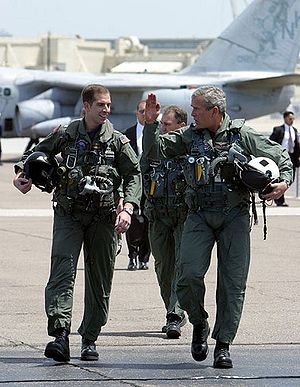 President George W. Bush walks across the tarm...