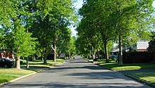 A straight street of a grid pattern in a 1950s suburb exhibiting low density, single family detached housing Grid Street-Low Density.jpg