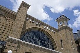 Une gare avec une façade en brique et une horloge sur un côté