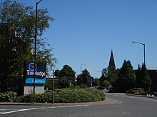 Church Road in Lowfield Heath village, looking east towards St Michael and All Angels Church. No houses remain here; a hotel, depots and light industrial units have replaced the earlier development.