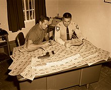 Monroe County police officers examining fake Cuban lottery tickets (c.1960) MM00038365x (9274609137).jpg