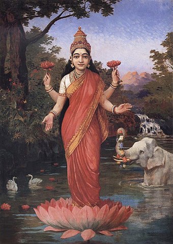 Goddess Lakshmi holding and standing on a lotus.