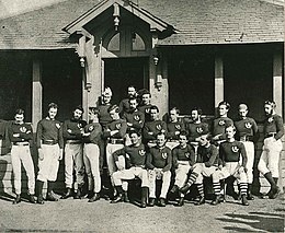 un groupe de joueurs, en tenue, prend la pause sur trois rangs désordonnés (assis, debout, debout) pour être photographiés.