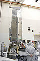 Workers at Kennedy Space Center on 29 March 2003 prepare to connect Spitzer to its payload attach fitting, which will connect the satellite to its Delta II launch vehicle.