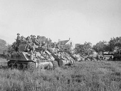 טנקי שרמן מתקדמים לעבר קן ב-18 ביולי 1944