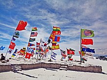 The Salar de Uyuni is a major tourist destination in Bolivia. The Salar De Uyuni Uyuni Flags Salt Desert Bolivia.jpg