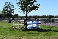 A young tree with a 'Welcome to Beverley' banner unfortunately pointing potential visitors to the wrong side of the Westwood at the 2023 Tour of Britain in the East Riding of Yorkshire.