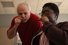 A music therapist from a "Blues in the Schools" program plays harmonica with a US Navy sailor at a Naval Therapy Center. USMC-05376.jpg