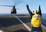 US Navy 060321-N-7526R-041 Boatswain's Mate 2nd Class Edgardo Bauzon signals to an Army CH-47 Chinook helicopter assigned to the 52nd Aviation Regiment Camp from Humphreys Korea.jpg