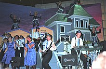 Phi Sigma Kappa and Alpha Chi Omega paired for 1987's winning entry, "Hitchcock," shown here in mid-song. 1987 U of Minnesota Campus Carni, Phi Sigma Kappa and Alpha Chi Omega pairing, showing band and ballyhoo.jpg