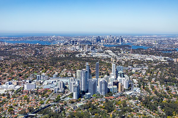 An aerial image looking south over Chatswood, with St Leonards and the Sydney central business district in the distance.