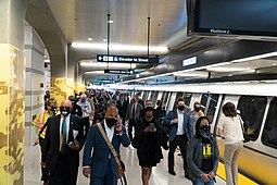 A crowd of Bay Area Rapid Transit riders in June 2020 following CDC face mask guidelines at Milpitas station in Milpitas, California. BART Milpitas station platform 2 at opening ceremony.jpg