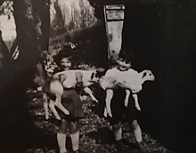 Claude et Danielle, enfants en 1944, dans la ferme Grandou avec chacun un agneau dans les bras