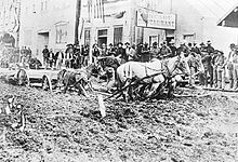 Front Street in Dawson with wagon stuck in mud, 1898