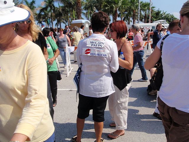 A woman wearing a sign saying, "Another Democrat for McCain/Palin"