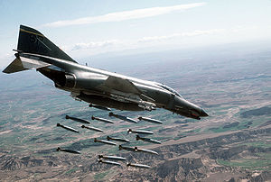 A United States Air Force F-4 Phantom II releasing aerial bombs over a bombing range in Bardenas Reales, Spain in 1986 F-4E-81st-tfs.jpg