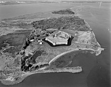 Schuine luchtfoto ten noordwesten van Fort Delaware en Pea Patch Island.  overblijfselen van de oceaanmuur zichtbaar op de voorgrond en rechts van de afbeelding.