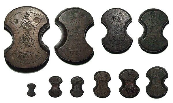 A set of ten traditional Japanese fundō weights, used by money changers to weigh coinage. Top row from left are 30 ryō (1124.66 g), 20 ryō (749.07 g) 