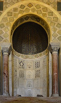 Foto des Mihrab der Großen Moschee von Kairouan, dessen aktueller Zustand, datiert 862-863, dem aghlabiden Prinzen Abu Ibrahim Ahmed zu verdanken ist.  Es ist eine sorgfältig dekorierte Nische, die ungefähr in der Mitte der südlichen Wand, genannt Qibla, der Gebetshalle angeordnet ist.