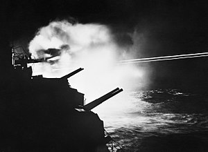 HMS MAURITIUS firing during a night action against enemy ships off the French coast between Brest and Lorient, 23 August 1944. A25321.jpg
