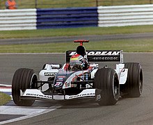 Photograph of Wilson in a racing car leaving a curve