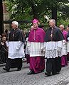 Kanovníci a biskup v chórovém oblečení s rochetami