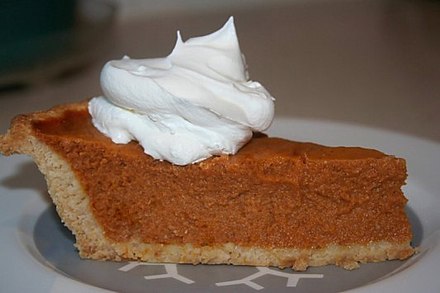 A slice of homemade pumpkin pie with whipped cream