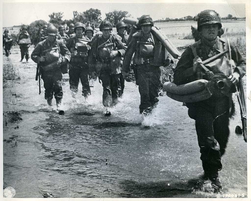 SC 190061-S - American troops of the 8th Inf. Regt., 4th Inf. Div., wade through land flooded by Hitler's forces in an unsuccessful attempt to make glider landings impractical, on Utah Beach, France. (51213009414)