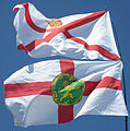 A bandeira de Jersey e a bandeira de Alderney ondeando xuntas.