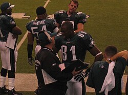 Owens (81) with the Eagles talking to a coach.