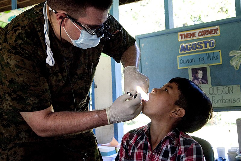 File:U.S. Navy 1st Lt. Jason Dulac, a dental officer with the 31st Marine Expeditionary Unit, injects a numbing agent into a boy's jaw before extracting a rotten tooth at Quinlogan Elementary School, Palawan 111022-M-VG363-049.jpg