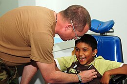 US Navy 081028-N-3173B-027 Cmdr. John King évalue les réflexes d'un patient atteint de paralysie cérébrale à l'établissement de santé du district d'Arima dans le cadre de la mission d'assistance humanitaire et civique Continuing Promise (CP) 2008.jpg