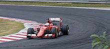 Sebastian Vettel turning into a right-hand corner on a asphalt racing surface